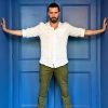 Richard Armitage against blue door with his arms stretched